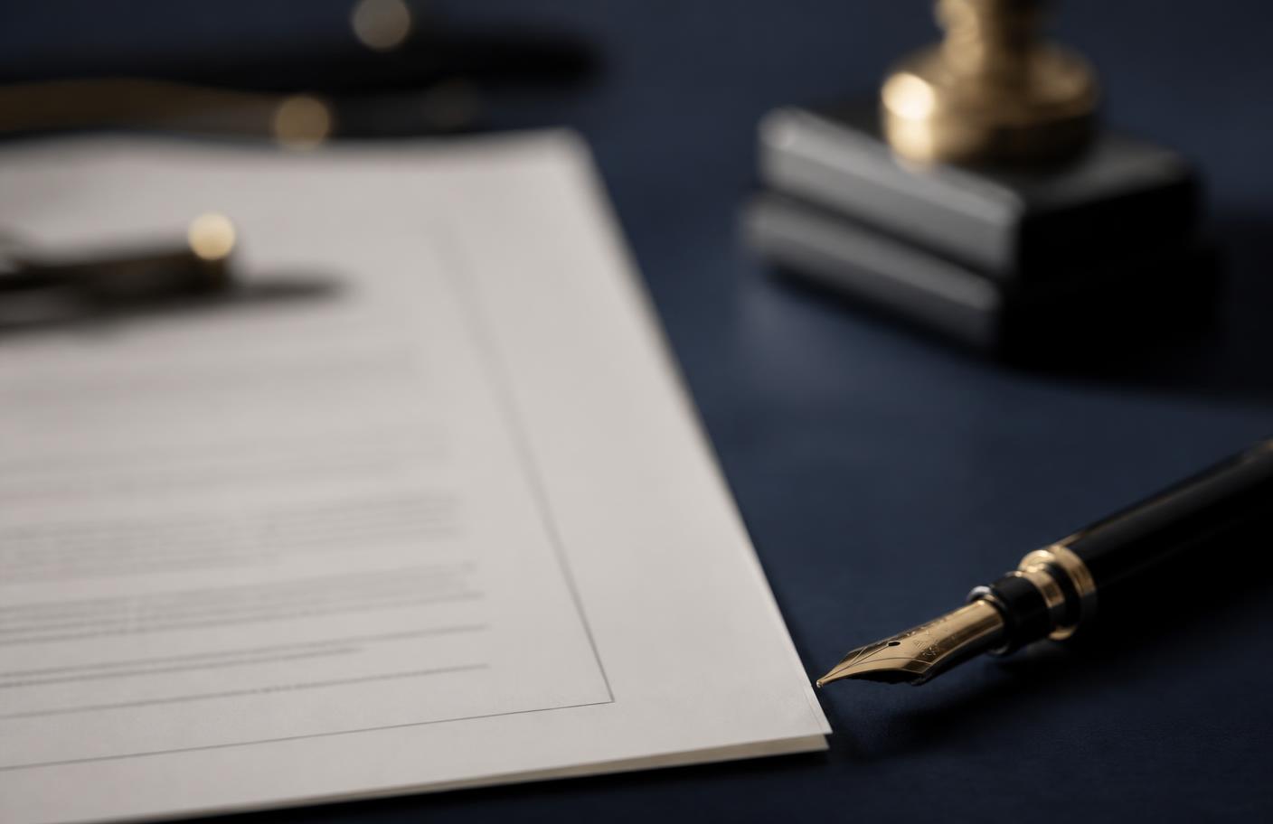 Legal documents and a fountain pen on a desk